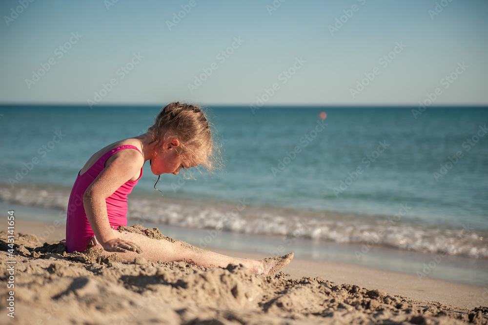 Cute little girl playing in the sand on the sea beach Stock Photo ...