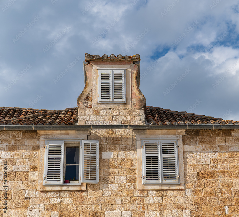 View of the old ruined roof and the façade of a sunny building View of the old ruined roof and the façade of a sunny building