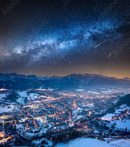 Milky way and illuminated Zakopane in winter at night
