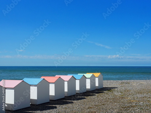 White cabanas with pastel roofs on the coast of Le Treport, France photo