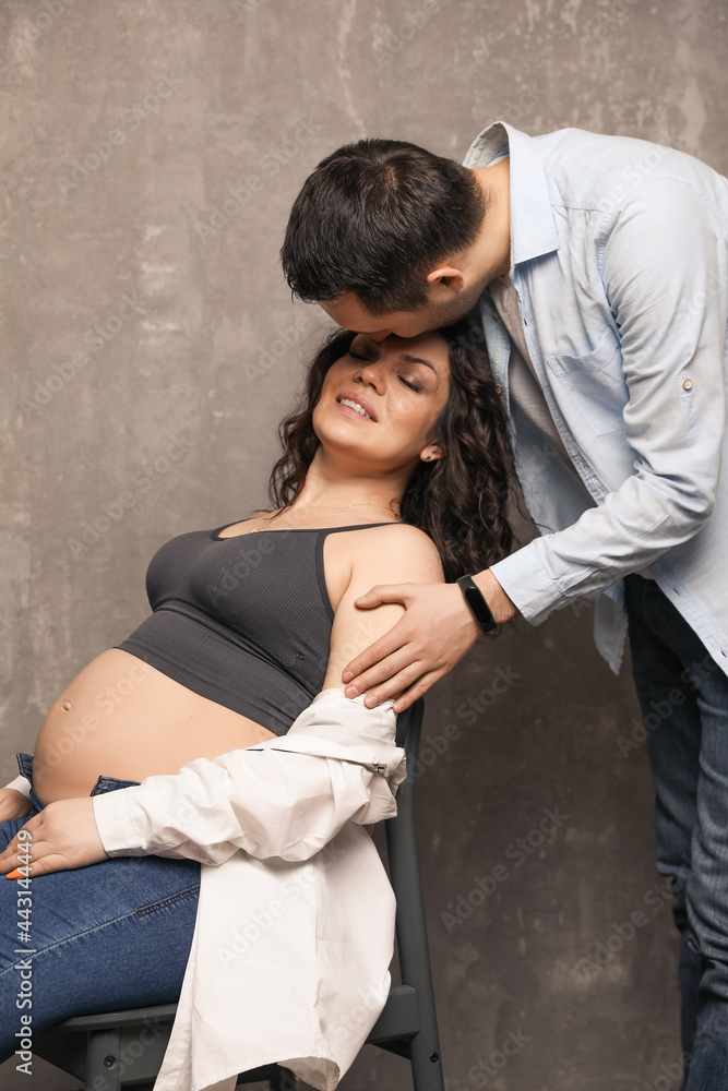 Beautiful happy couple is expecting a baby. A married couple expecting a child in a photo studio. Beautiful happy couple is expecting a baby. A married couple expecting a child in a photo studio.
