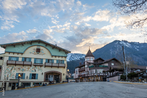 Bauernhaus style Bavarian buildings with snow covered mountains in the distance in the town of Leavenworth, Washington. photo