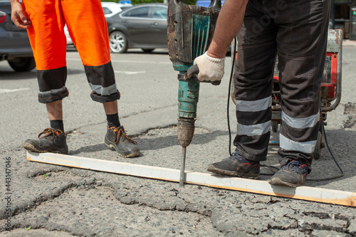 He removes the asphalt with a jackhammer. Removing the asphalt layer from the road.