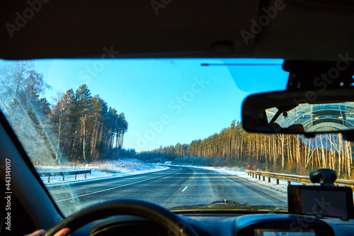View from of car interior from side of driver to the road and nature landscape through the windshield