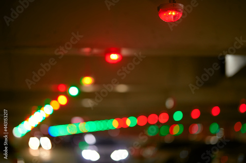 Red light close up and green lights in background, park system technology concept. Smart car parking signals in garage area. Blur background