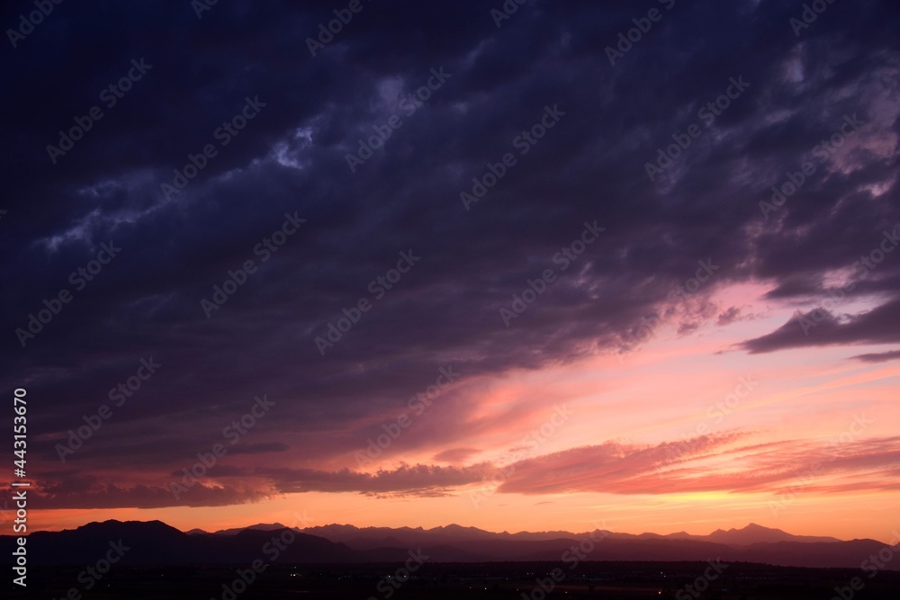 colorful purple-hued sunset  over the front range of the colorado rocky mountains, as seen from broomfield, colorado