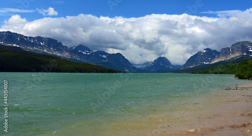 the turquoise-colored water of lake sherburne and   beautiful glaciated peaks of glacier national park, montana     photo