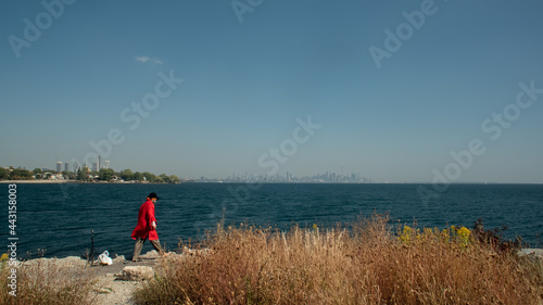 Pirate in red dress looking at the city across the ocean