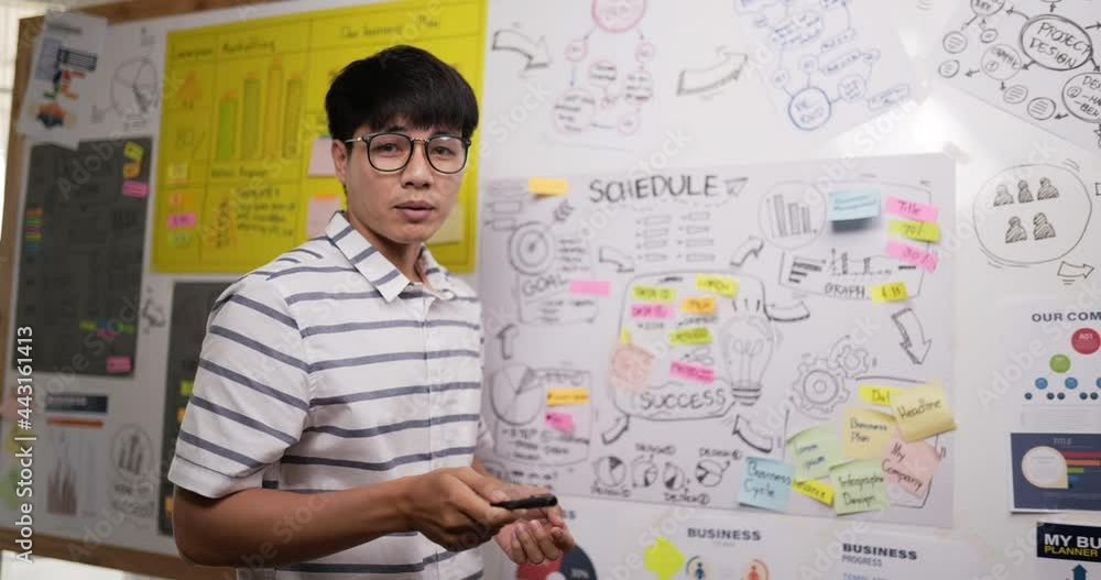 Asian businessman glasses pointing and explaining the information Asian businessman glasses pointing and explaining the information