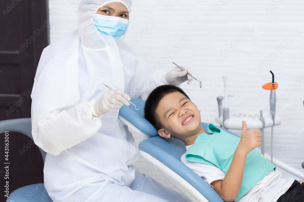 Dentist examining Asian little boy teeth in clinic. Dentist examining Asian little boy teeth in clinic.