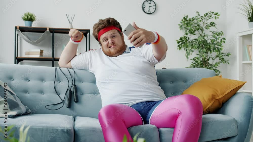 Guy in retro sports clothing is taking selfie with smartphone camera