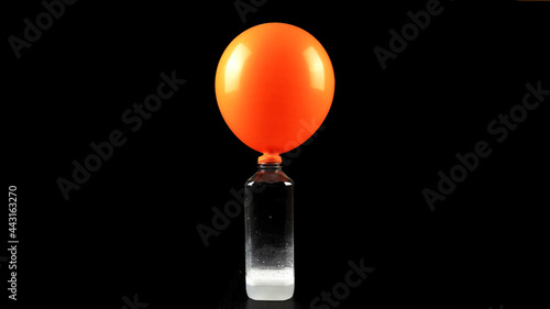Foto Blow up balloons using the science of baking soda and vinegar on black backgroun