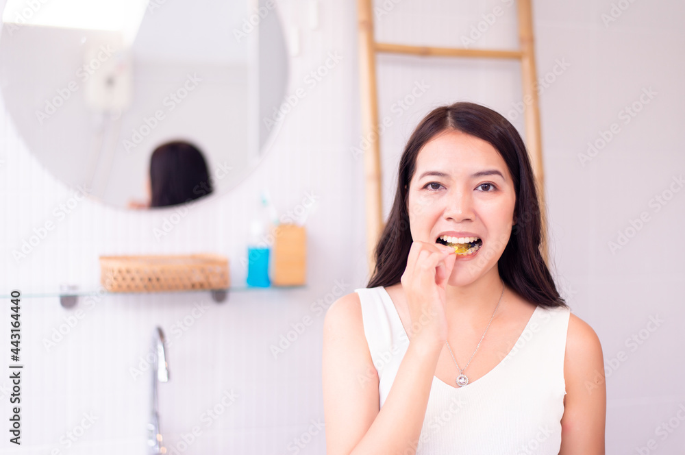 Asian woman putting braces teeth or silicone trainer,Orthodontic,Dental health concept,Decayed tooth Asian woman putting braces teeth or silicone trainer,Orthodontic,Dental health concept,Decayed tooth