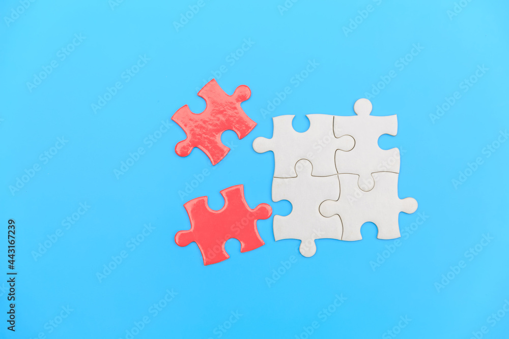 jigsaw puzzle on a blue background. Completing final task, missing jigsaw puzzle pieces and business concept with a puzzle piece missing. jigsaw puzzle on a blue background. Completing final task, missing jigsaw puzzle pieces and business concept with a puzzle piece missing.