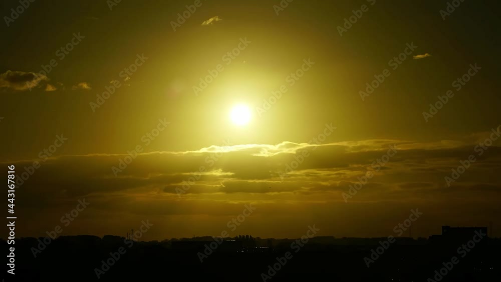 Time-lapse of sunset, crepuscular ray passing through floating clouds Time-lapse of sunset, crepuscular ray passing through floating clouds