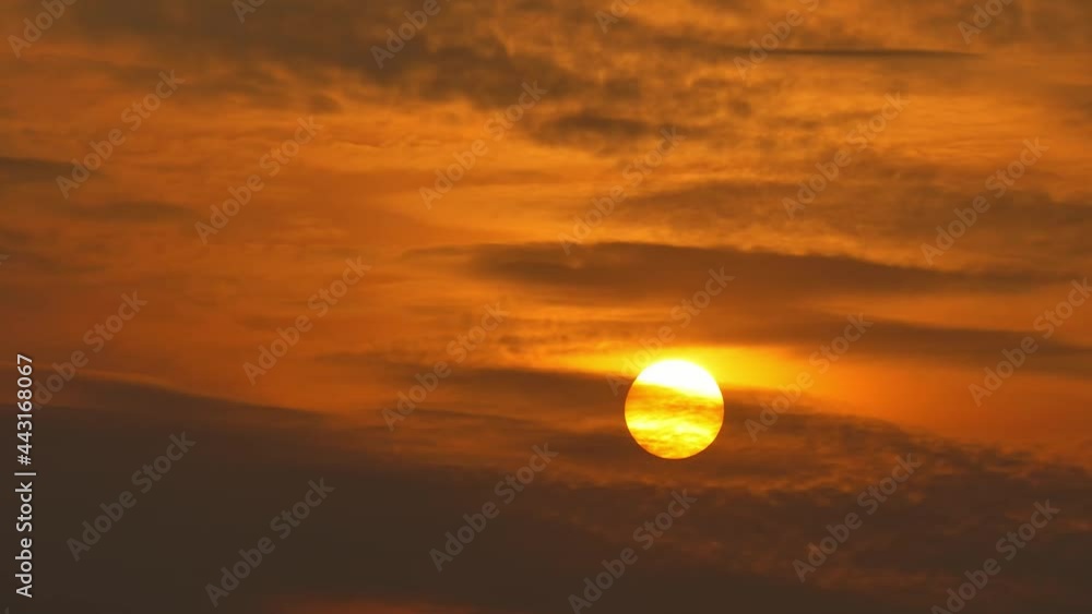 Time-lapse of sunset, orange sun passing through clouds Time-lapse of sunset, orange sun passing through clouds