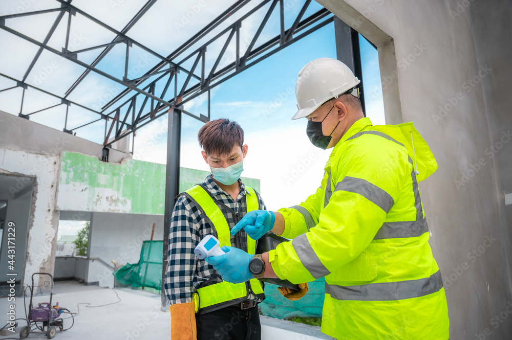 Coronavirus concept and the construction industry : Civil engineer supervisors measure temperature of construction workers at construction sites. fever test Measure temperature in construction site. Coronavirus concept and the construction industry : Civil engineer supervisors measure temperature of construction workers at construction sites. fever test Measure temperature in construction site.