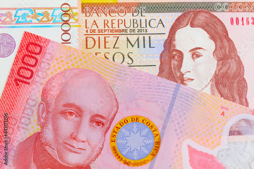 A macro image of a brown ten thousand bank note from Colombia paired up with a colorful red one thousand colones bank note from Costa Rica.  Shot close up in macro.