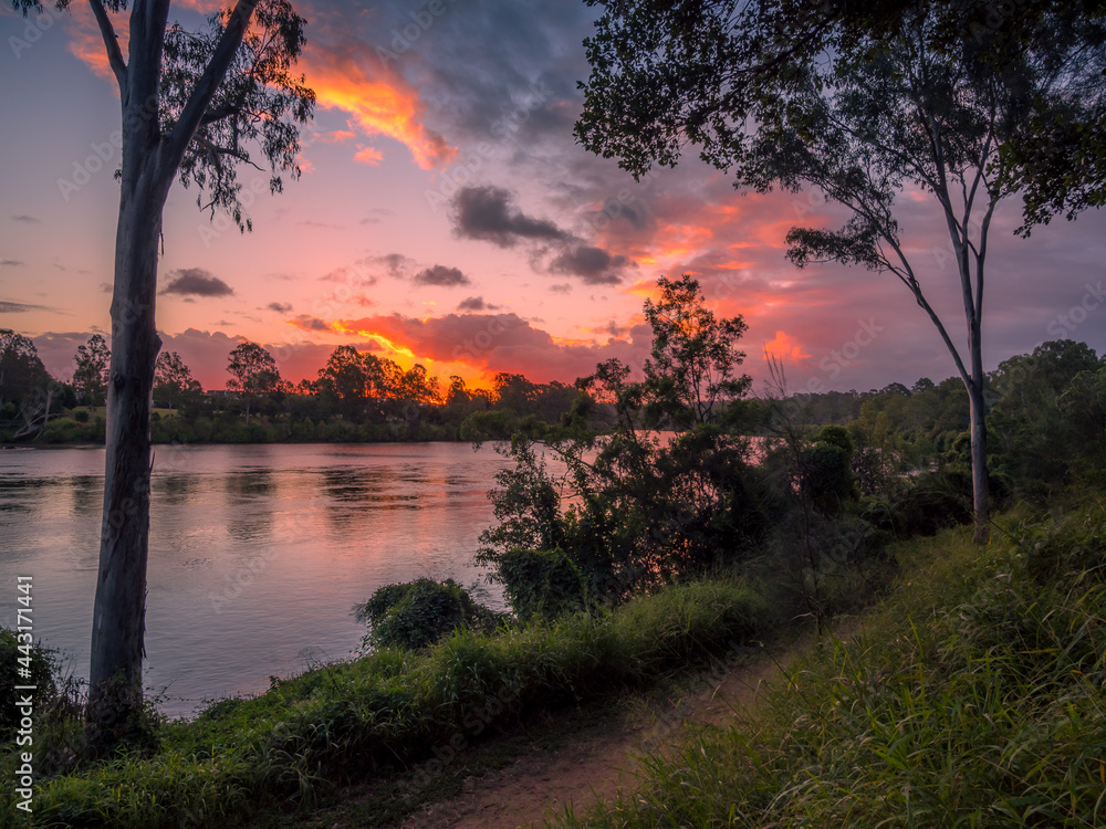 Obraz premium Golden Riverside Sunset with Reflections