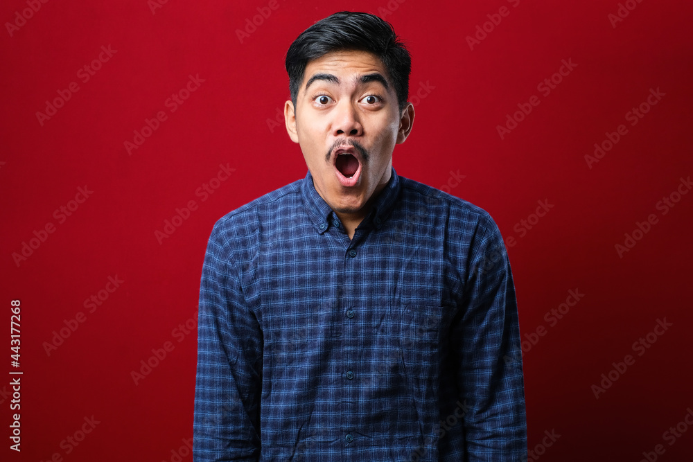 Amazed asian young man with open mouth and bulging eyes looking at camera Amazed asian young man with open mouth and bulging eyes looking at camera