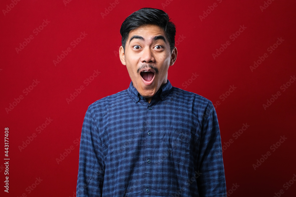 Amazed asian young man with open mouth and bulging eyes looking at camera Amazed asian young man with open mouth and bulging eyes looking at camera