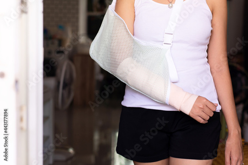 Patient woman wearing arm sling for relieve broken arms at home © gballgiggs