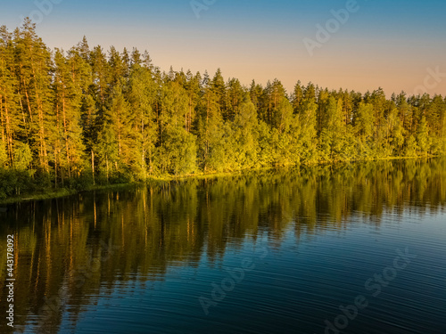 Trees are reflected in the forest lake. Wonderful sunset. Desktop wallpaper