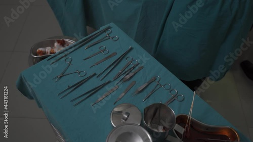 surgery taking scalpel scissors from surgical table
