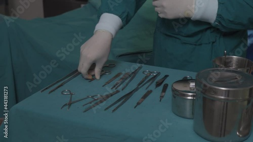 surgery taking scalpel scissors from surgical table