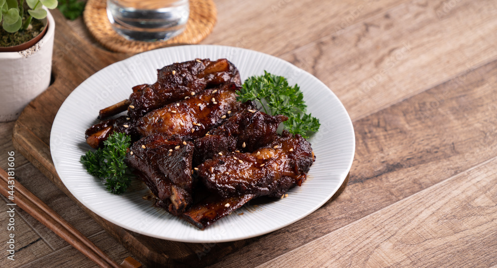 Fototapeta premium Barbecue pork spare ribs in a plate on wooden table background.