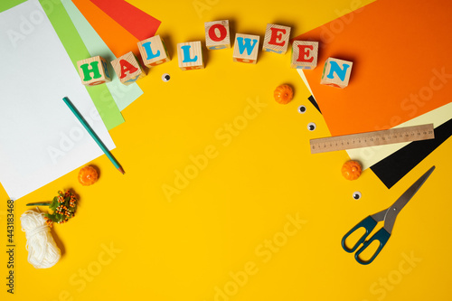 Happy halloween holiday concept. DIY children decorations on bright yellow background. Halloween party greeting card. Flat lay, top view, overhead.