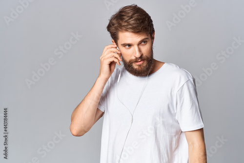 man in t-shirt with beard studio posing light background