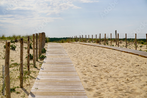 wooden path coast access with sand beach waves entrance to ocean atlantic sea