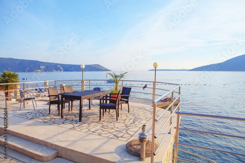 Restaurant terrace on the coast . Perfect place for romantic dinner . Seaside terrace with no people 