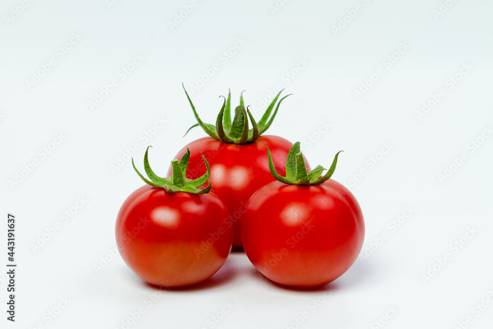 Three red fresh tomatoes on a light background. View from above. Vegetarian food concept. Three red fresh tomatoes on a light background. View from above. Vegetarian food concept.