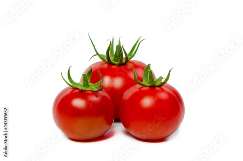 Three red fresh tomatoes on a white isolated background. Vegetarian food concept.
