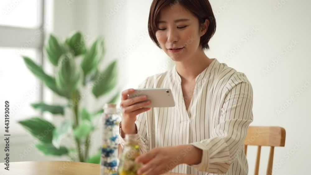 ハーバリウムをスマートフォンで撮影する女性 ハーバリウムをスマートフォンで撮影する女性