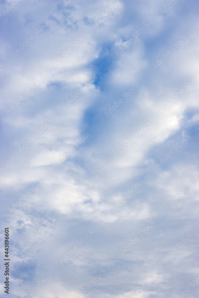 Fully covered moving bright white clouds under the blue sky vertical view