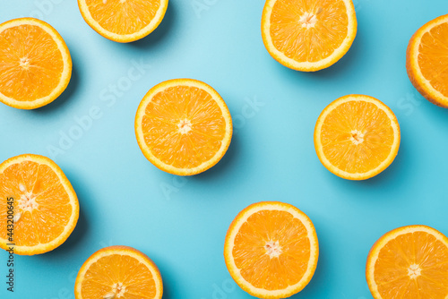 Top view photo of juicy orange slices on isolated light blue background