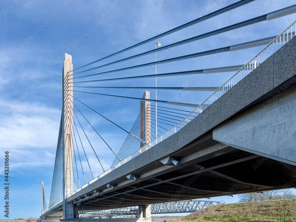Obraz premium De Martinus Nijhoffbrug in Zaltbommel is een oeververbinding over de rivier de Waal. Op de kabelbrug rijdt het verkeer van de snelweg de A2, met daarnaast de spoorbrug met de naam Dr. W. Hupkesbrug.
