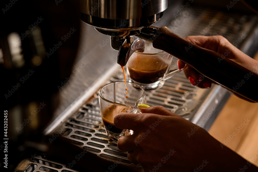 close-up of stream of coffee flowing from an espresso machine into cup