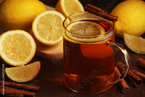 A mug with hot tea with lemons and cinnamon sticks