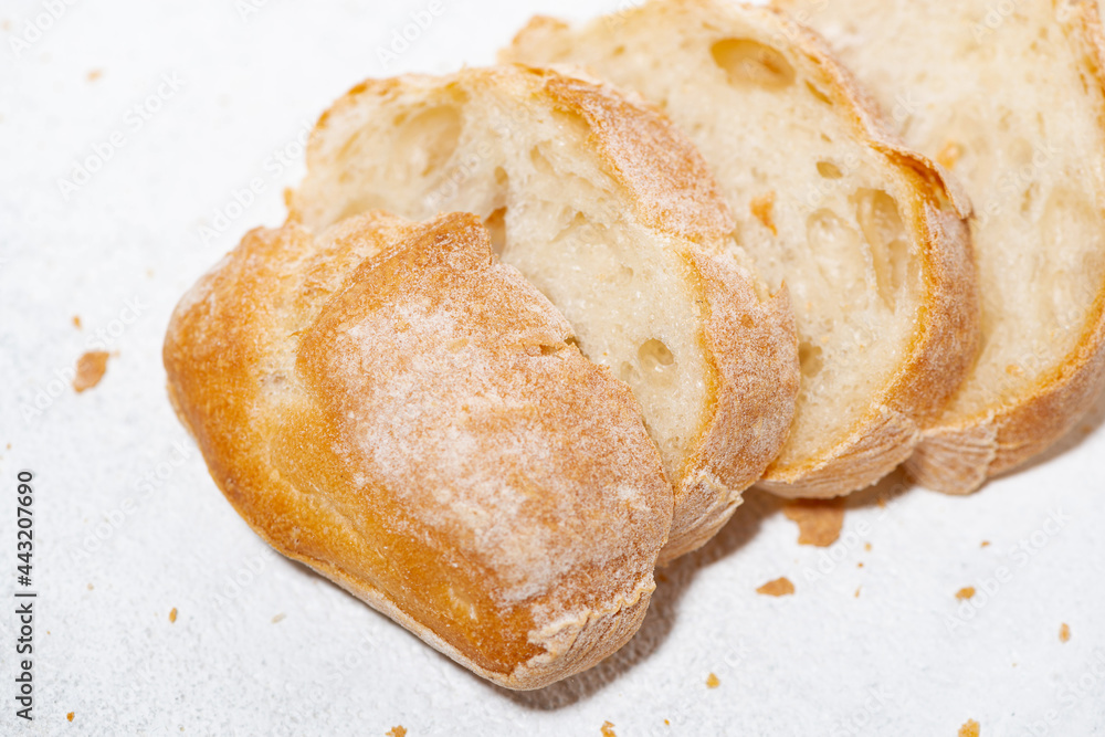 white bread cut into slices on white background, closeup
