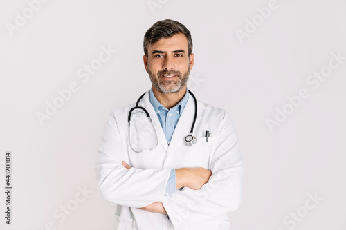 Handsome doctor smiling and standing on white background © Cris C.
