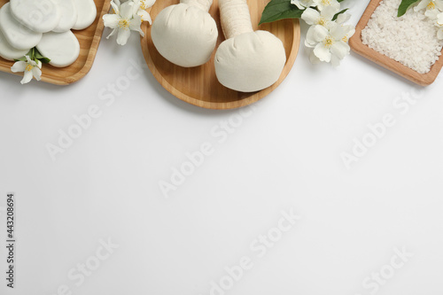 Flat lay composition with spa stones and beautiful jasmine flowers on white background, space for text