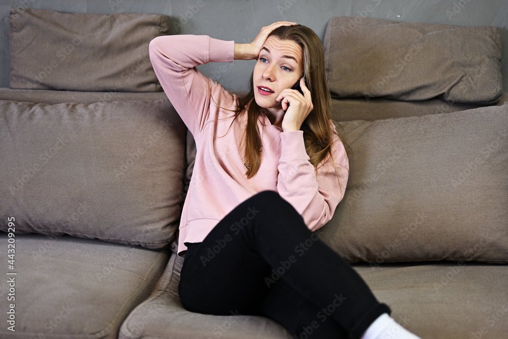 Portrait of cute caucasian girl talking phone at home while sitting on couch Portrait of cute caucasian girl talking phone at home while sitting on couch