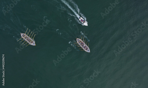 Aerial drone view of sport canoe operated by team in mediterranean clear waters.