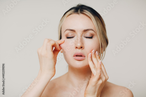 Woman doing facial gymnastics self yoga massage and tighten up face skin