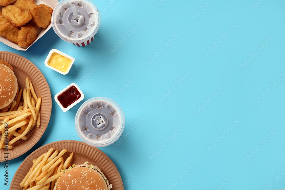 Different fast food on turquoise background, flat lay. Space for text Different fast food on turquoise background, flat lay. Space for text