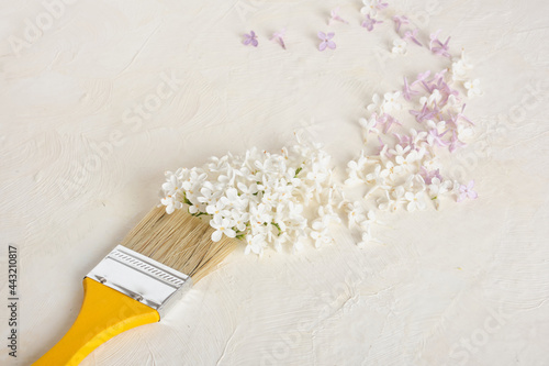 paint brush and lilac flowers on a light textured background